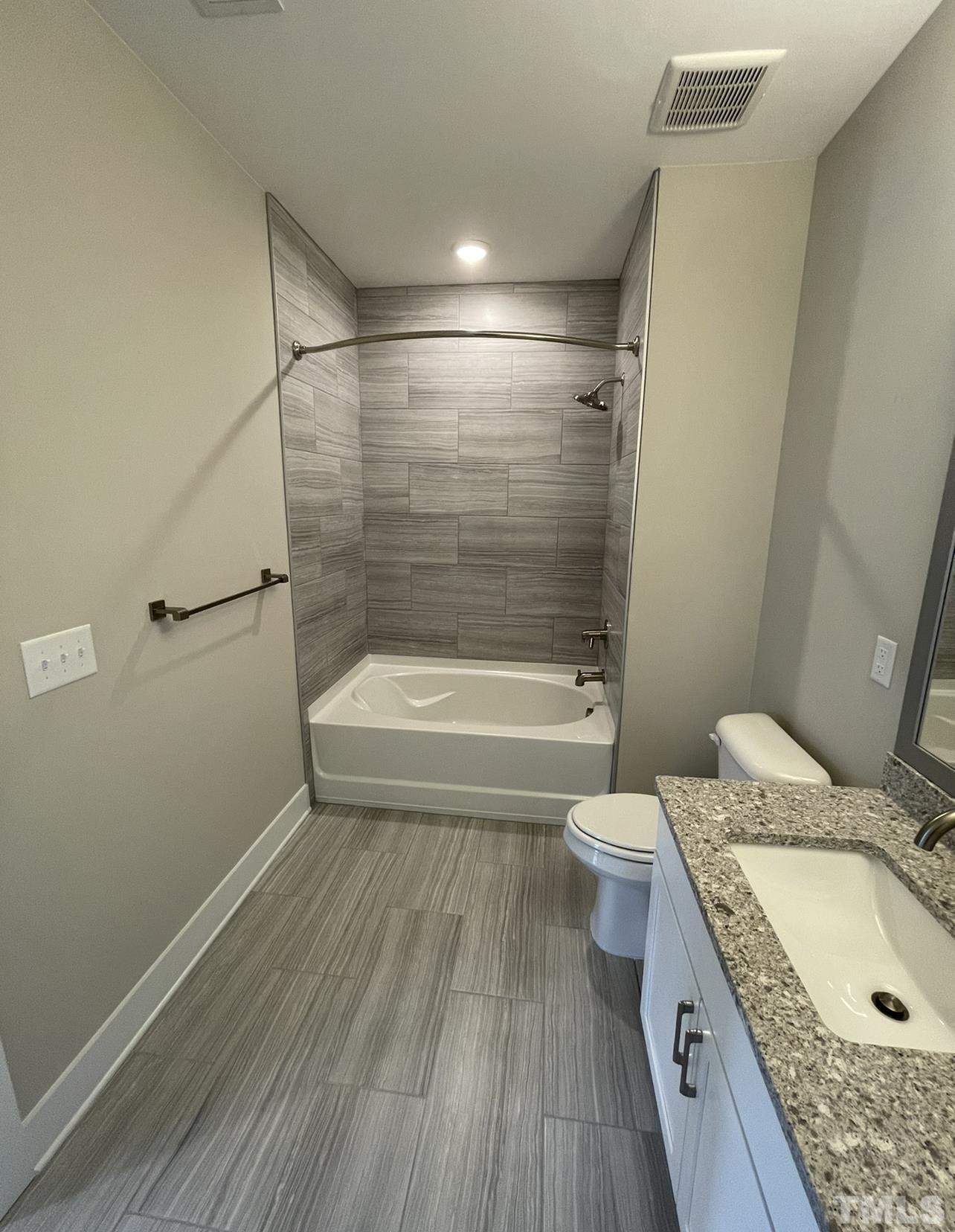 105 Chatham Walk Lane, Unit 404 Cary, NC 27511 - Photo 20 of 33 a bathroom with a granite countertop toilet a sink and bathtub