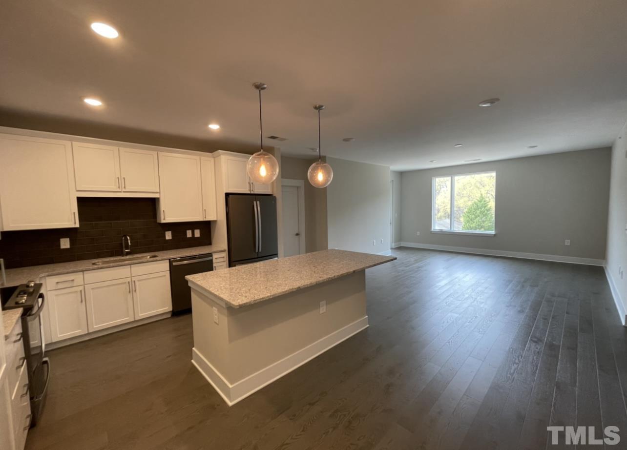 105 Chatham Walk Lane, Unit 404 Cary, NC 27511 - Photo 2 of 33 a large kitchen with kitchen island a sink dishwasher a refrigerator and wooden floor