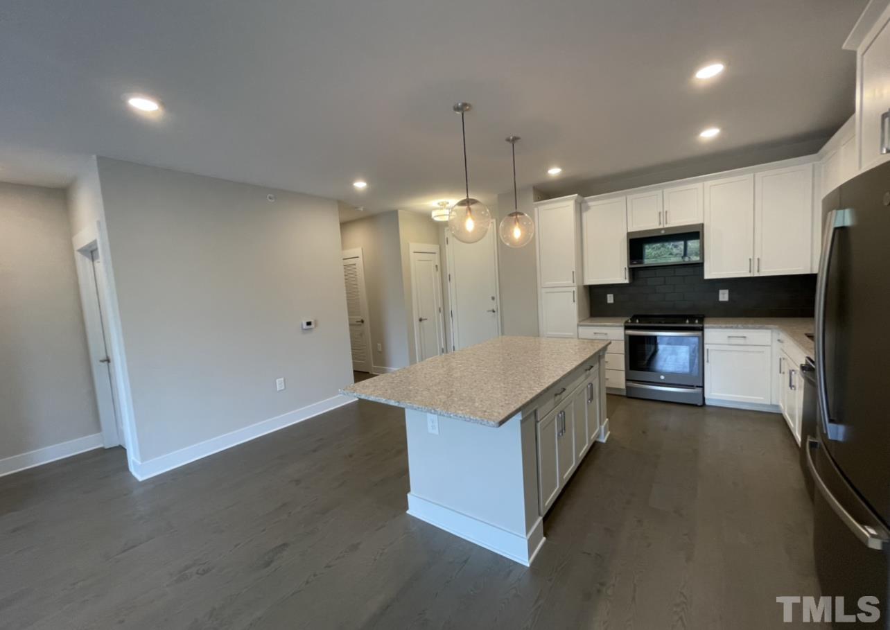 105 Chatham Walk Lane, Unit 404 Cary, NC 27511 - Photo 10 of 33 a large kitchen with a large counter top stainless steel appliances and cabinets
