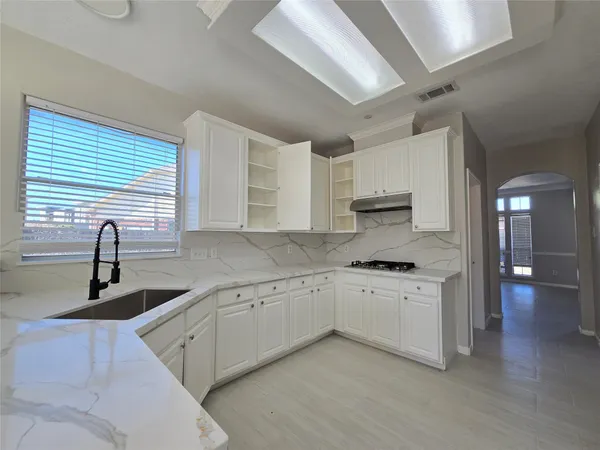 a kitchen with granite countertop a sink stainless steel appliances and cabinets