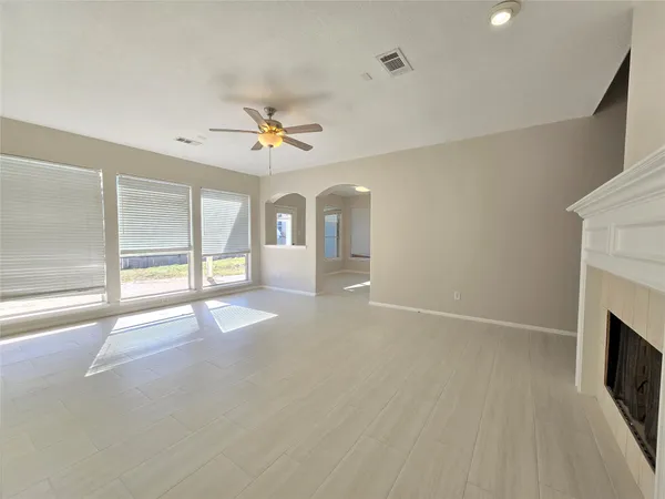 a view of an empty room with a fireplace and a window