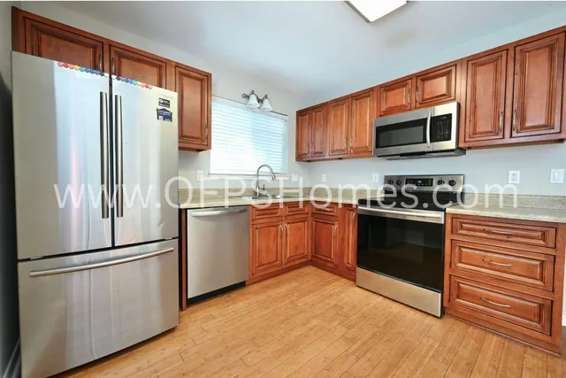a kitchen with stainless steel appliances a refrigerator sink and microwave