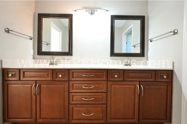 a bathroom with a double vanity sink and a mirror