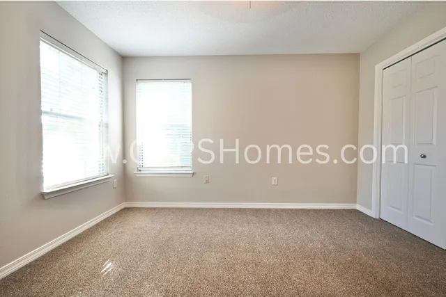 an empty room with fan and windows