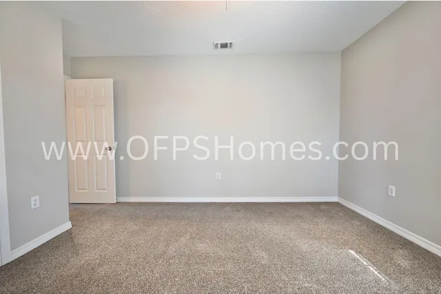 an empty room with a ceiling fan and window