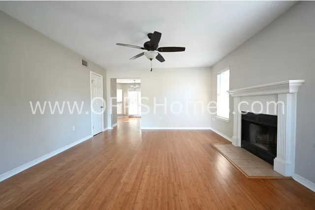 a view of empty room with wooden floor and fireplace