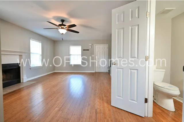 a view of a livingroom with wooden floor and a ceiling fan