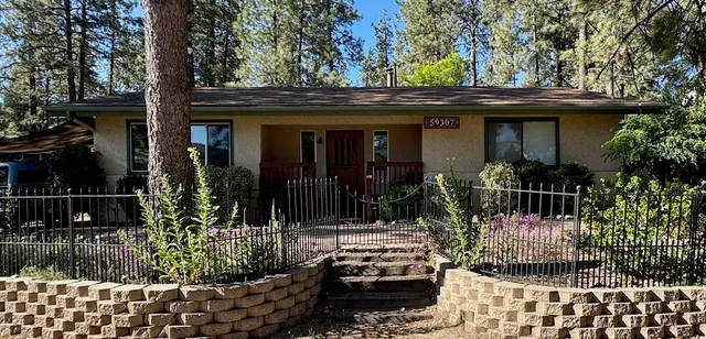 a view of a house with potted plants and a fountain