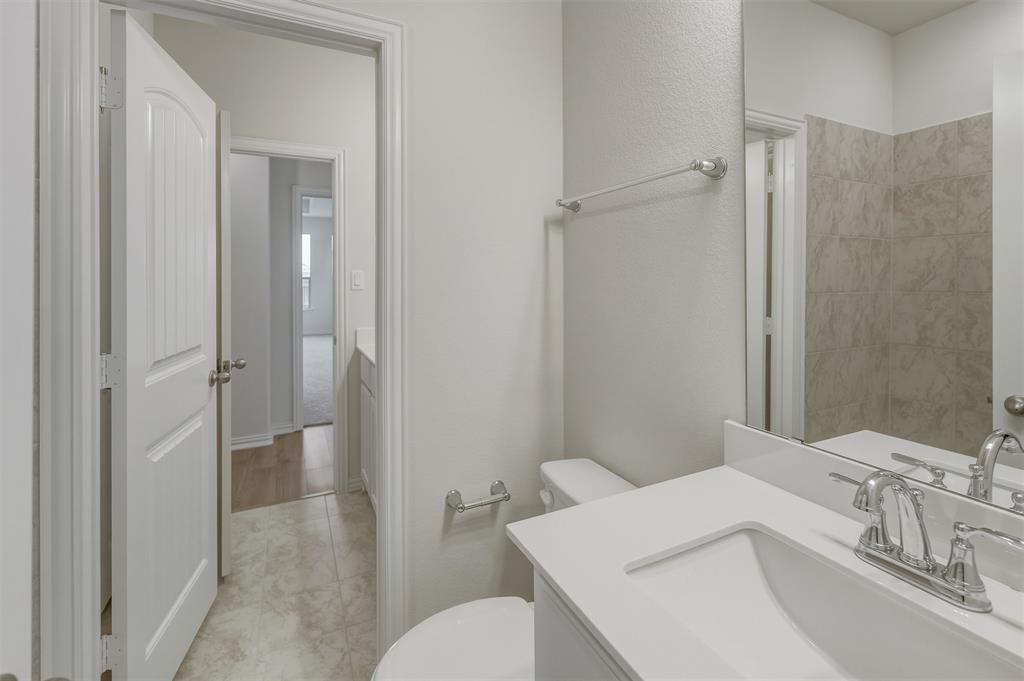 1217 Colca Drive Springtown, TX 76082 - Photo 15 of 25 Bathroom featuring a white vanity with an integrated sink, polished chrome faucet, and a large mirror
