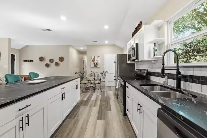 201 Winfield Thicket Road Bastrop, TX 78602 - Photo 6 of 36 a large kitchen with granite countertop a sink and cabinets
