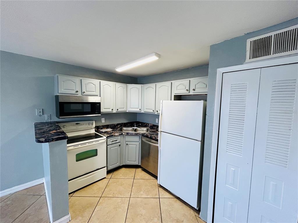 Undisclosed Address Orlando, FL 32811 - Photo 2 of 9 a kitchen with a refrigerator stove and microwave