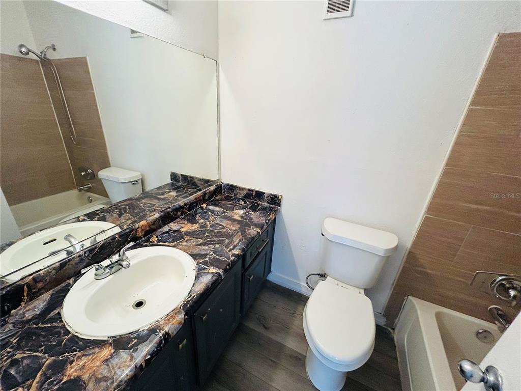 Undisclosed Address Orlando, FL 32811 - Photo 8 of 9 a bathroom with a granite countertop toilet sink and mirror
