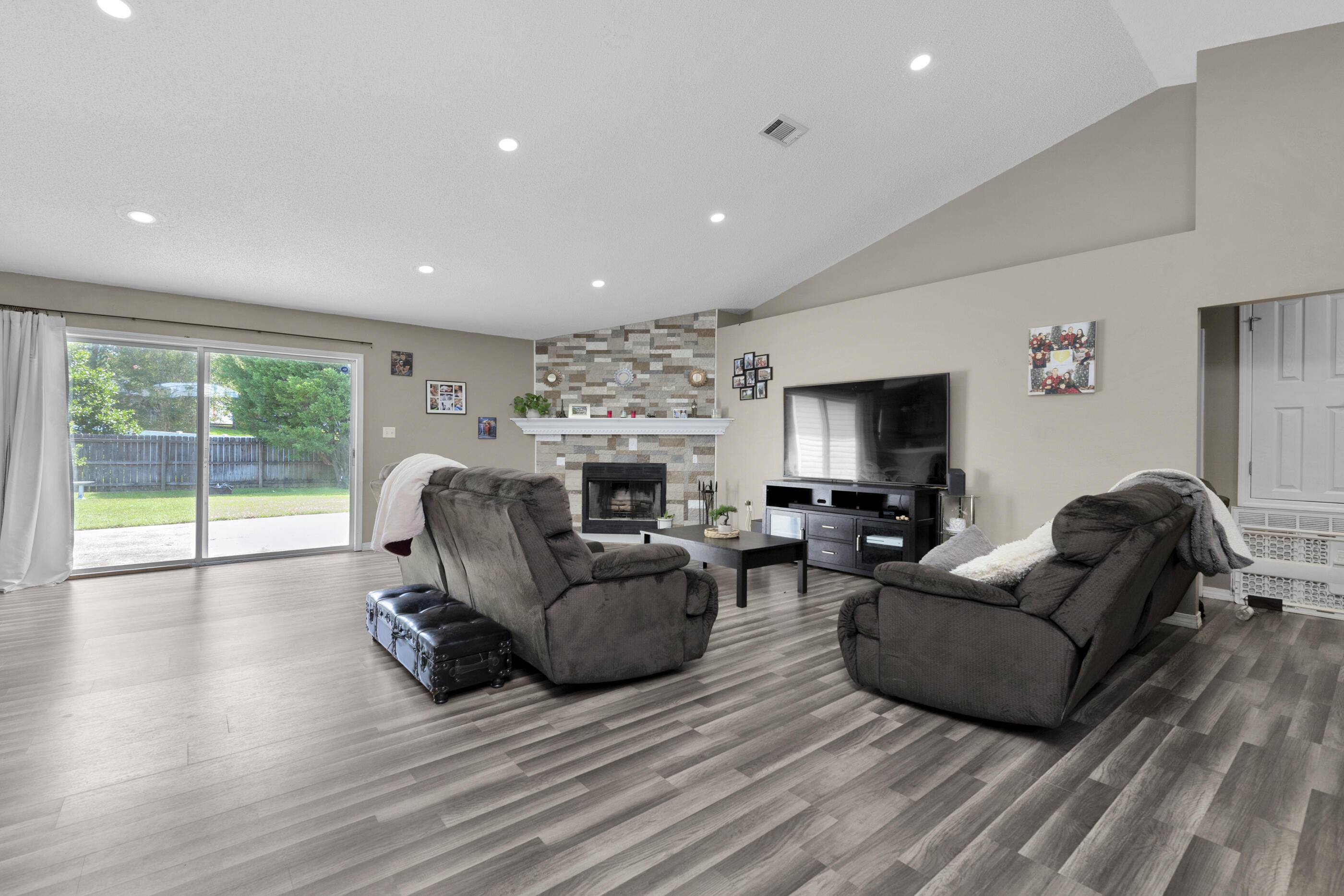 6215 Shire Lane Crestview, FL 32536 - Photo 12 of 36 a living room with furniture a fireplace and a flat screen tv