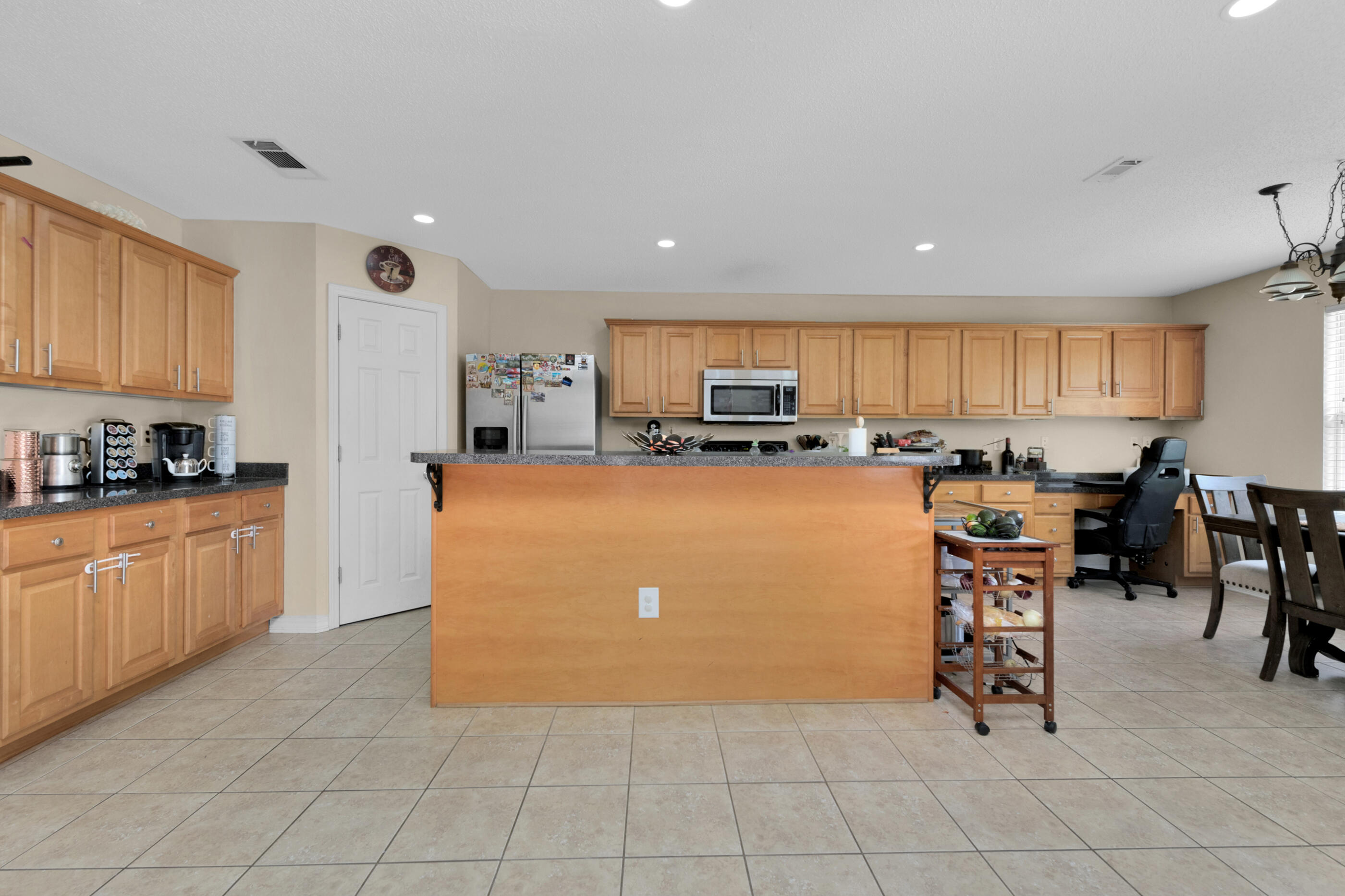 6215 Shire Lane Crestview, FL 32536 - Photo 14 of 36 a kitchen with stainless steel appliances granite countertop a refrigerator top stove top oven a sink a dining table and chairs