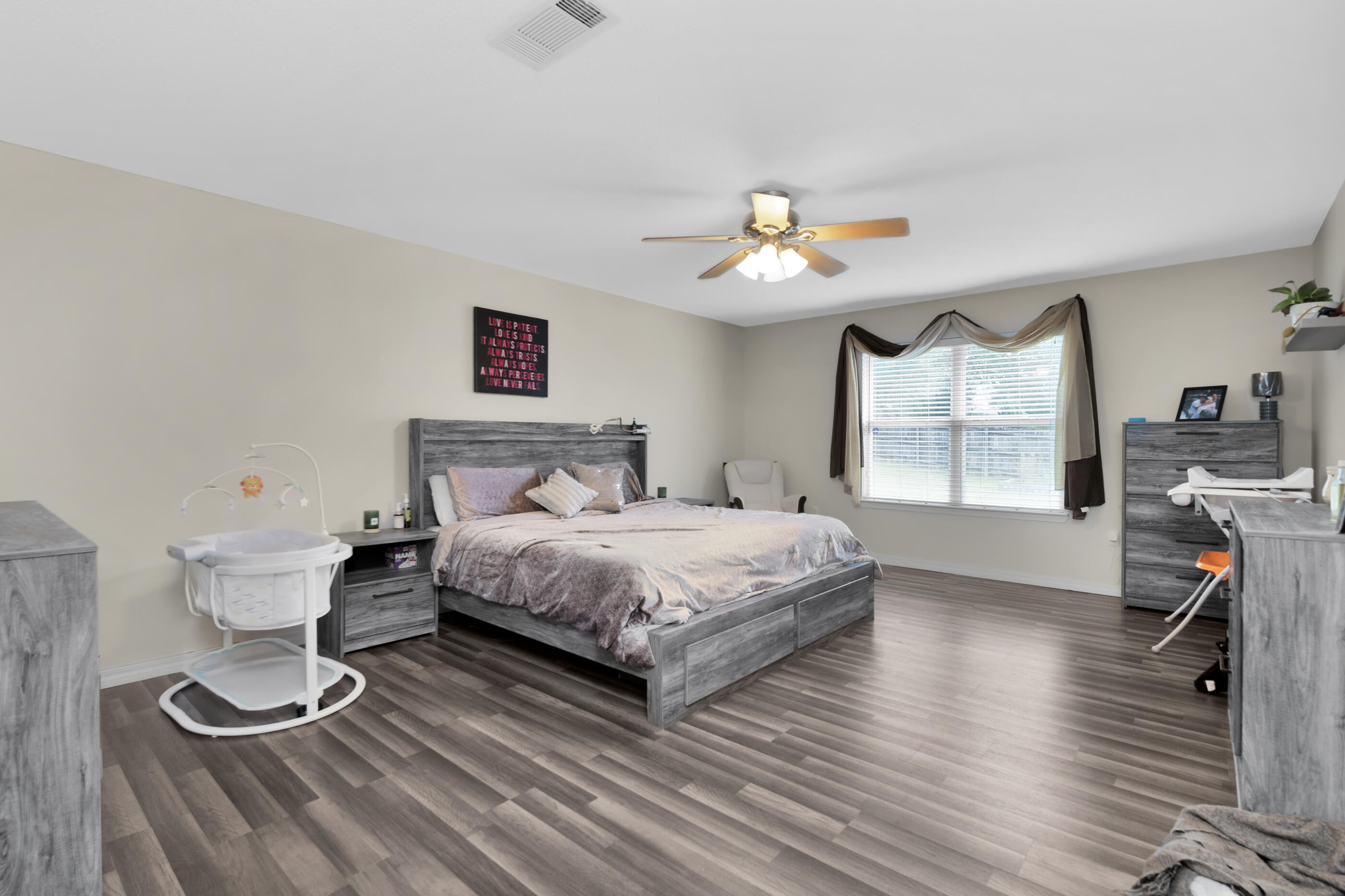 6215 Shire Lane Crestview, FL 32536 - Photo 23 of 36 a bedroom with a bed and wooden floor