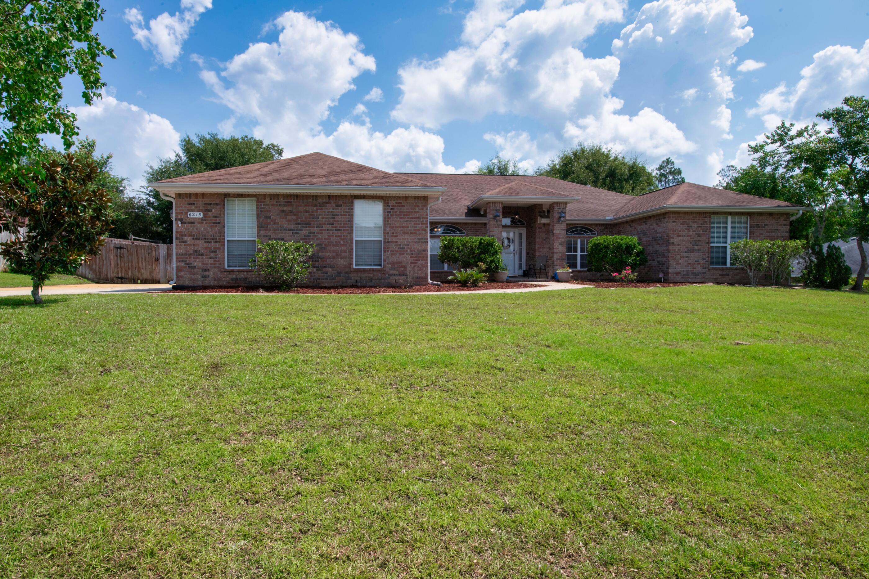 6215 Shire Lane Crestview, FL 32536 - Photo 3 of 36 a front view of a house with a garden