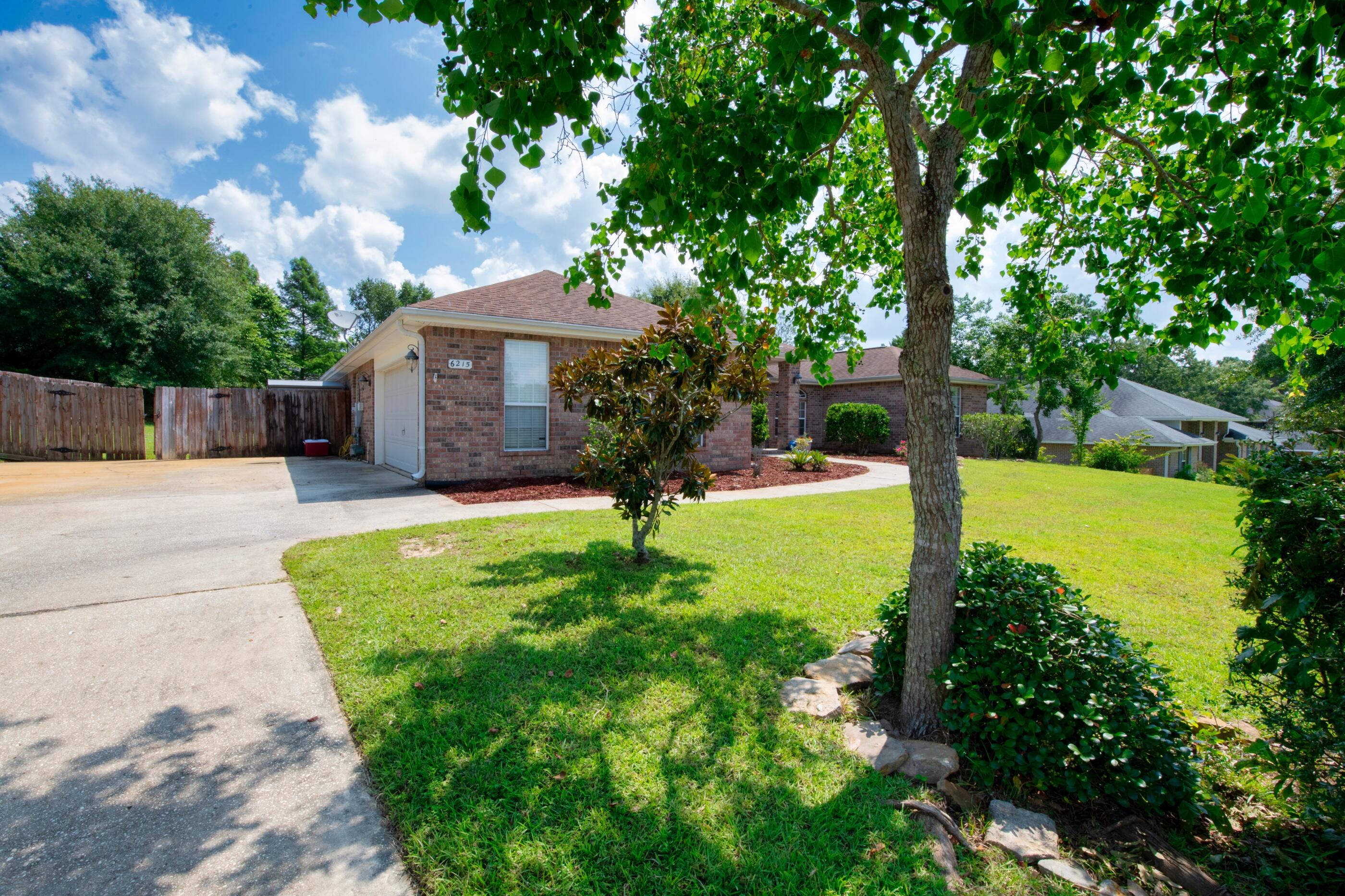 6215 Shire Lane Crestview, FL 32536 - Photo 5 of 36 a view of a backyard with a garden and trees