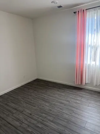 a view of a room with wooden floor and a window