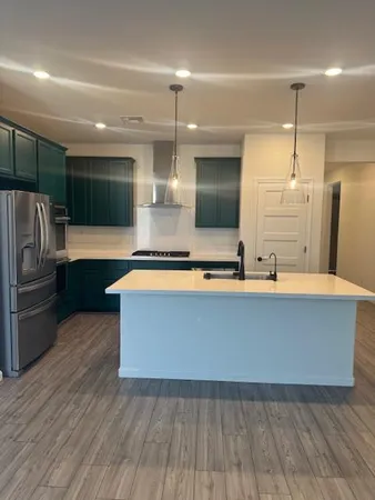 a large kitchen with stainless steel appliances a large counter top