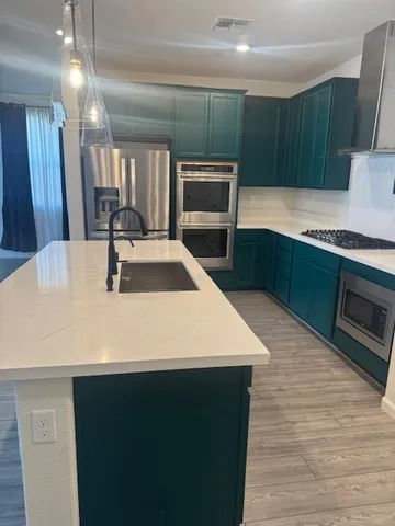 a kitchen with kitchen island a sink stainless steel appliances and cabinets
