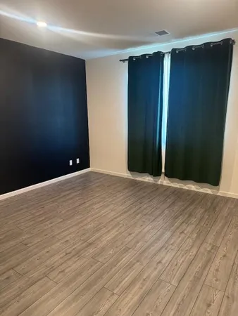 an empty room with wooden floor and closet