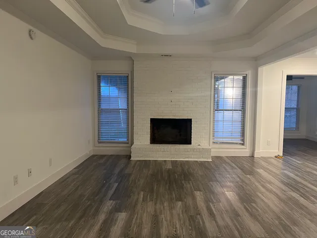 an empty room with wooden floor and fireplace