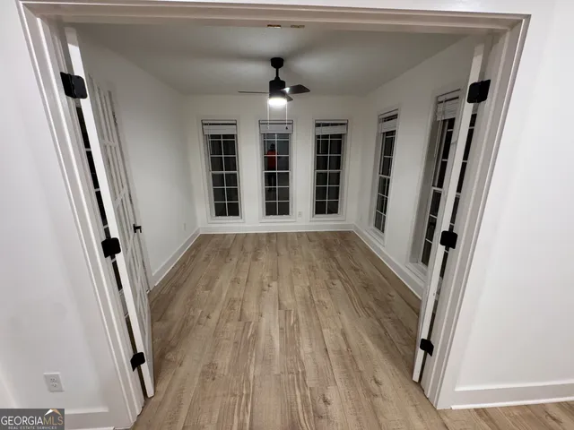 a view of an empty room with wooden floor