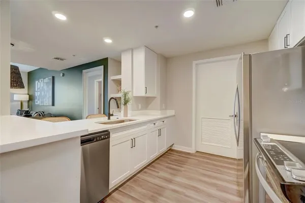 a large white kitchen with a sink and dishwasher stove