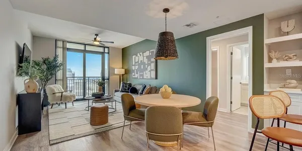 a dining room with furniture a chandelier and wooden floor
