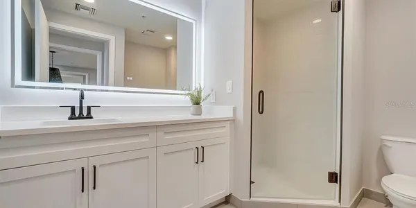 a bathroom with a sink a toilet and shower