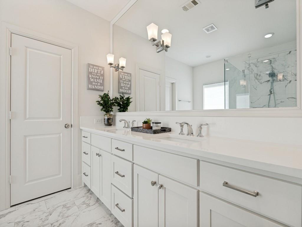 732 West 7th Street Dallas, TX 75208 - Photo 13 of 25 Dual vanity with white cabinetry and brushed nickel hardware, expansive white countertop, and large wall-mounted mirror