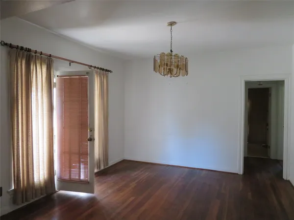 an empty room with wooden floor and window