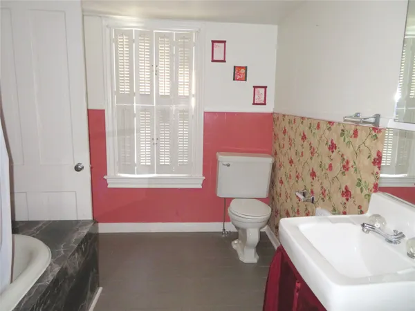 a bathroom with a sink toilet vanity and tub