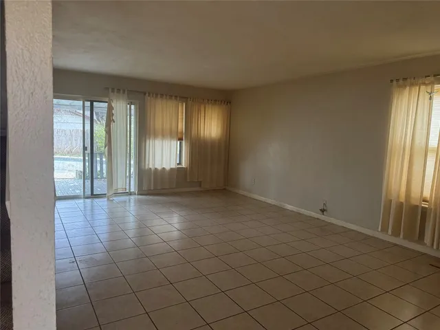 a view of an empty room with a fireplace and a window