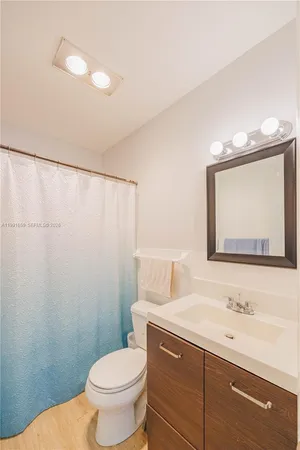 a bathroom with a toilet a sink and a mirror