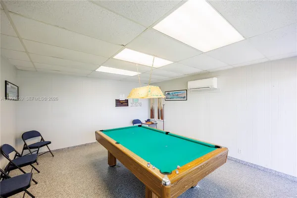 a room with pool table and a potted plant