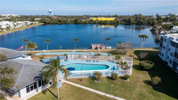 an aerial view of a house with swimming pool and lake view