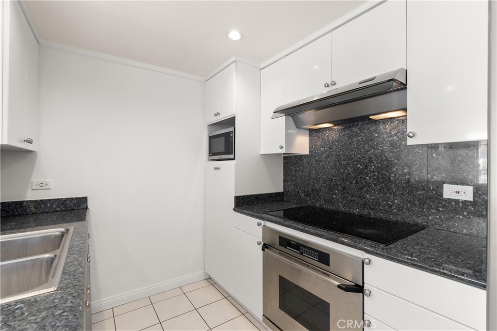10535 Wilshire Boulevard, Unit 912 Los Angeles, CA 90024 - Photo 13 of 33 a kitchen with granite countertop a stove and a sink