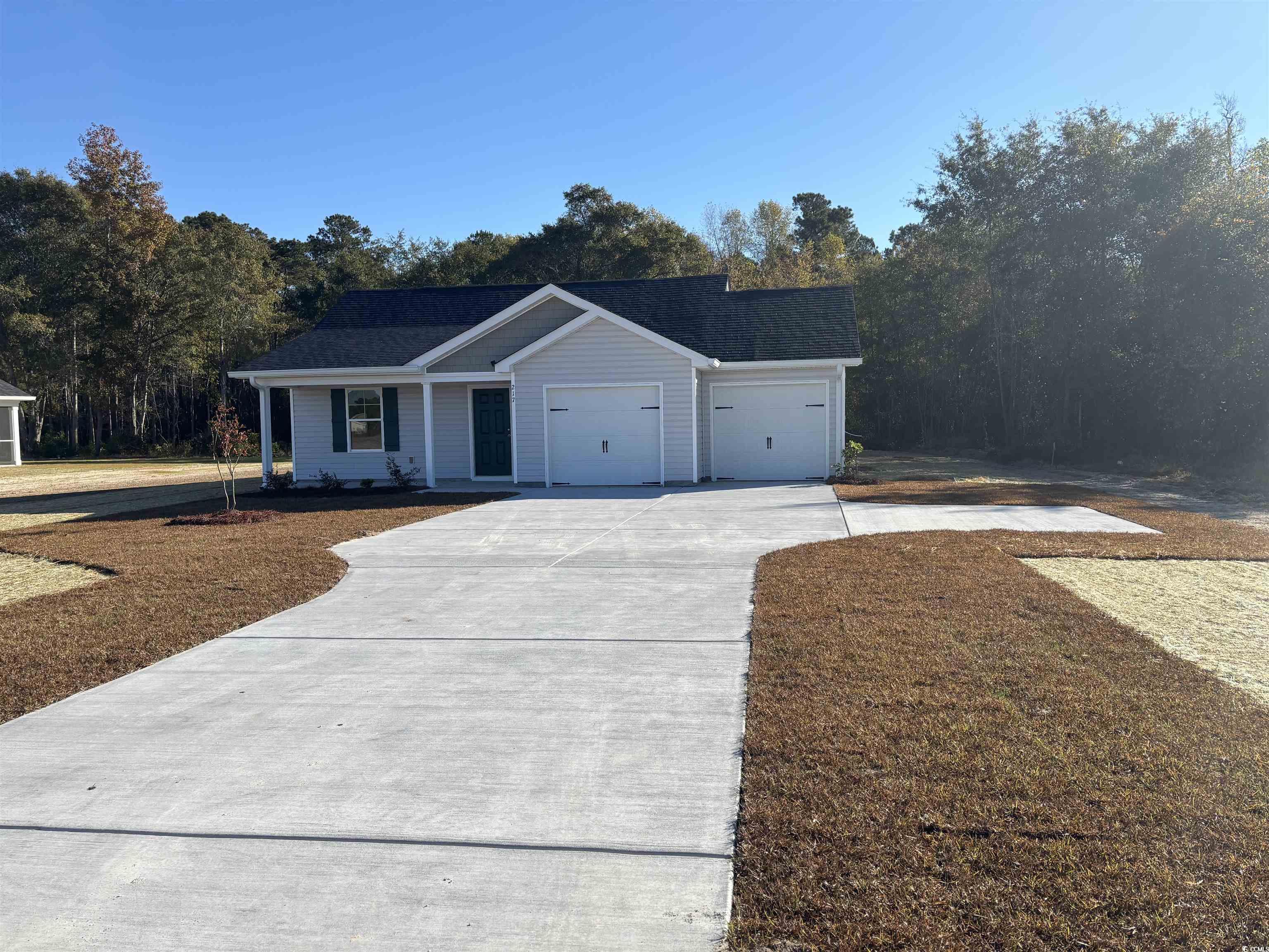 Ranch-style home featuring concrete driveway, a garage, and a porch