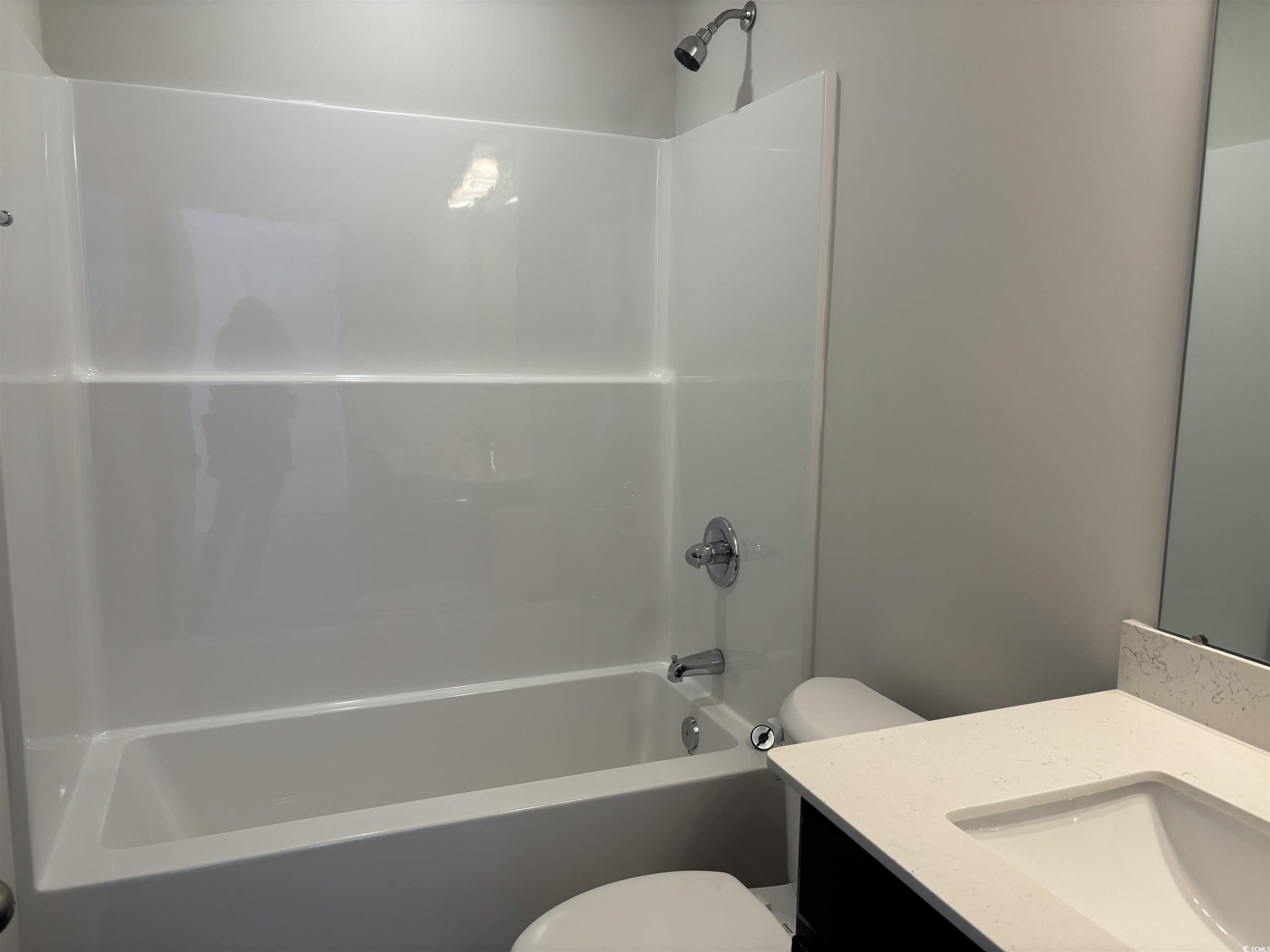 217 Kc Lane Aynor, SC 29511 - Photo 8 of 14 Spare room featuring a ceiling fan, dark wood-style flooring, and vaulted ceiling