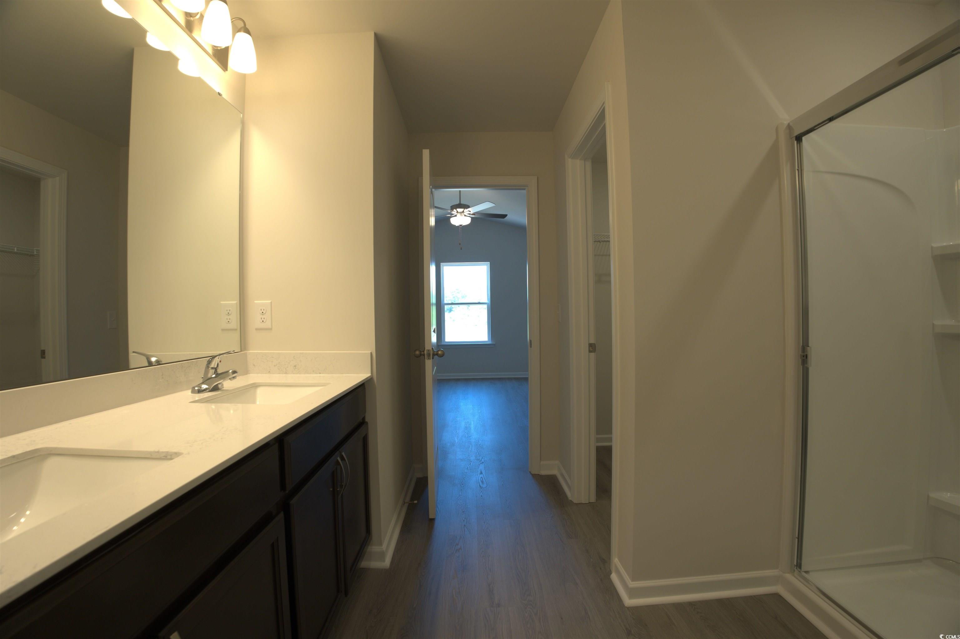 217 Kc Lane Aynor, SC 29511 - Photo 10 of 14 Full bathroom featuring wood finished floors, double vanity, and a shower
