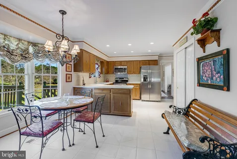 a dining room filled a chandelier and kitchen view
