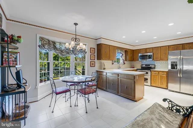 a kitchen with sink refrigerator dining table and chairs