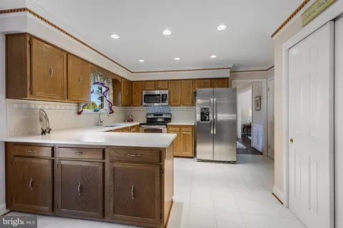 a kitchen with stainless steel appliances granite countertop a refrigerator a sink and a stove
