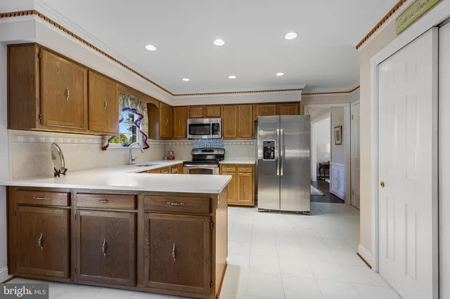 a kitchen with stainless steel appliances granite countertop a refrigerator a sink and a stove