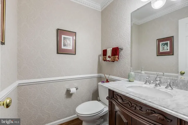 a bathroom with a granite countertop sink a toilet and a mirror