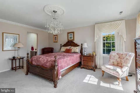 a spacious bedroom with a bed and a chandelier