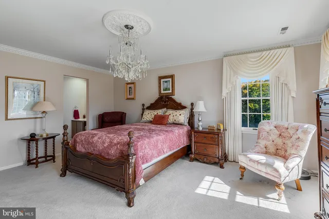 a spacious bedroom with a bed and a chandelier
