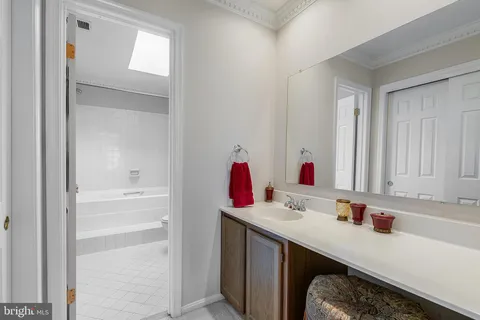 a bathroom with a sink vanity tub and a mirror