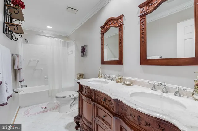 a bathroom with a granite countertop sink a toilet a mirror a vanity and bathtub